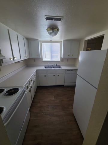 Goshen apartment for rent - A kitchen with white cabinets and a white fridge.