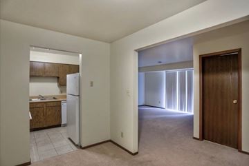 Chesterton apartment for rent - A kitchen with a refrigerator and wooden cabinets is visible through a doorway.