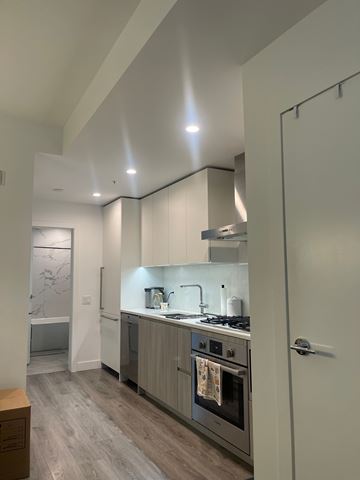 North Vancouver apartment for rent - A modern kitchen with a stove top oven and a refrigerator.