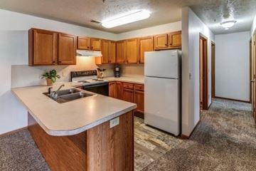 Middleville apartment for rent - A kitchen with wooden cabinets and a white refrigerator.
