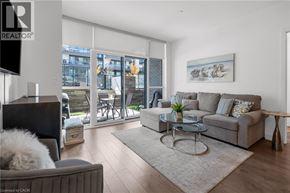 Innisfil condo for rent - A living room with a grey couch, a glass table, and a television.