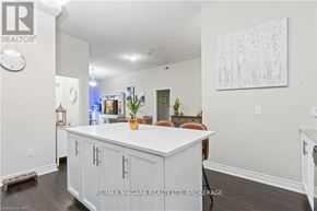 Niagara Falls (Mt. Carmel) condo for rent - A white kitchen with a large island and a painting on the wall.