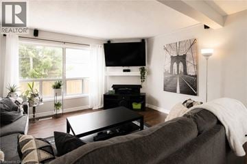 London townhouse for rent - A living room with a grey couch and a flat screen TV mounted on the wall.