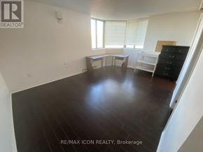 London East (East F) condo for rent - A room with a wooden floor and white walls.