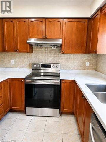 Hamilton townhouse for rent - A kitchen with wooden cabinets and a stainless steel oven.
