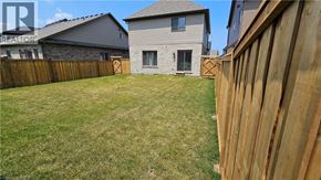 Collingwood apartment for rent - A backyard with a wooden fence and a house in the background.