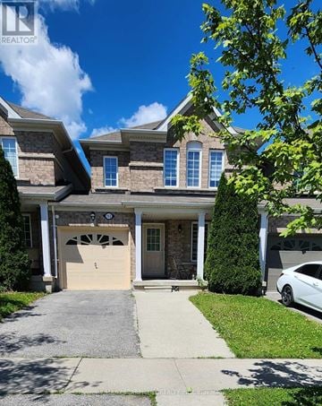 Brantford townhouse for rent - A large house with a stone facade and a garage door.