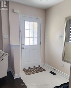 Brantford townhouse for rent - A white door is in a room with a brown rug on the floor.