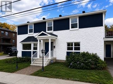 Ottawa apartment for rent - A white house with a black roof and a blue trim.