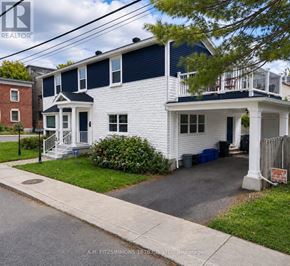 Ottawa apartment for rent - A white house with a blue trim and a porch.