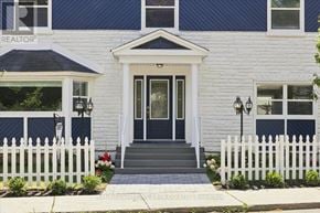 Ottawa apartment for rent - A white house with a black door and windows.