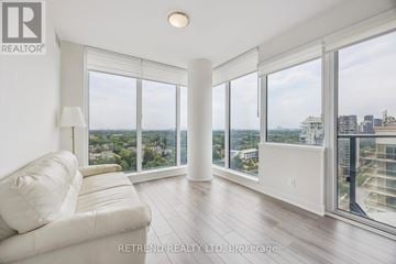 Toronto (Willowdale West) condo for rent - A white couch sits in a bright room with floor to ceiling windows.