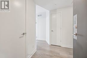 Toronto (Willowdale West) condo for rent - A hallway with a door on the right and a sign on the wall.