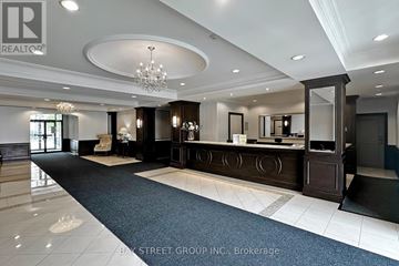 Markham (Commerce Valley) condo for rent - A well-lit, spacious lobby area with a reception desk and a chandelier.