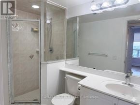 Toronto (Willowdale East) condo for rent - A white bathroom with a toilet, sink, and shower.