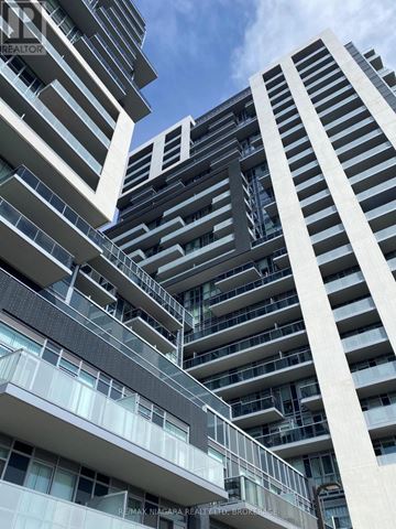Burlington (Freeman) condo for rent - A tall building with a balcony on the second floor.