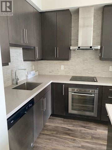 Burlington (Freeman) condo for rent - A kitchen with black cabinets and a white countertop.