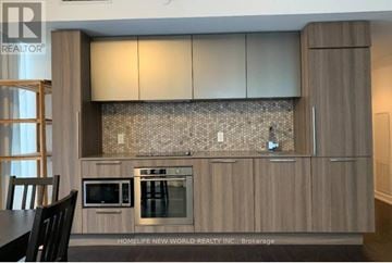 Toronto (Church-Yonge Corridor) condo for rent - A kitchen with wooden cabinets and a microwave oven.