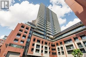 Toronto (Humber Heights) condo for rent - A tall building with a glass facade stands behind a smaller building with a red brick facade.