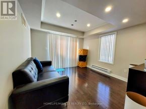 Brampton (Northwest Brampton) townhouse for rent - A living room with a black leather couch and wooden floors.