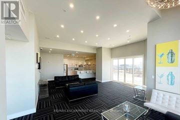 Milton (Be Beaty) condo for rent - A living room with a black couch and a glass coffee table.