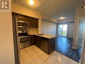 Milton (Be Beaty) condo for rent - A kitchen with a stainless steel refrigerator, microwave, oven, and cabinets.