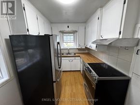 Ottawa apartment for rent - A kitchen with black appliances and white cabinets.