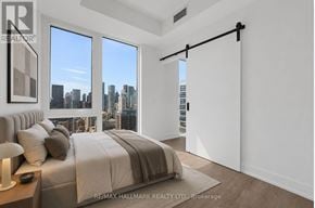 Toronto (Church-Yonge Corridor) condo for rent - A bedroom with a large bed and a view of the city.