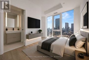 Toronto (Church-Yonge Corridor) condo for rent - A bedroom with a large bed and a city view through the windows.