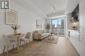 Toronto (Church-Yonge Corridor) condo for rent - A well-lit, modern living room with a dining table and chairs, a sofa, and a kitchen area with white cabinets.