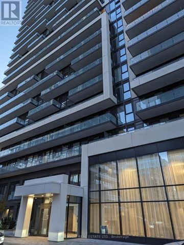Richmond Hill (Langstaff) condo for rent - A tall building with a glass facade and a sign that reads "REAL ESTATE LTD., Brokerage.".