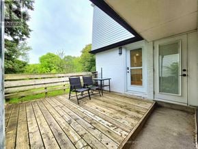 Newmarket (Huron Heights-Leslie Valley) apartment for rent - A wooden deck with a table and chairs is in front of a white house.