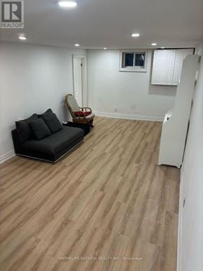 Newmarket (Huron Heights-Leslie Valley) apartment for rent - A living room with a black couch and wooden flooring.
