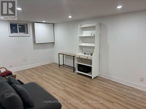 Newmarket (Huron Heights-Leslie Valley) apartment for rent - A living room with a grey couch and a white shelf unit.