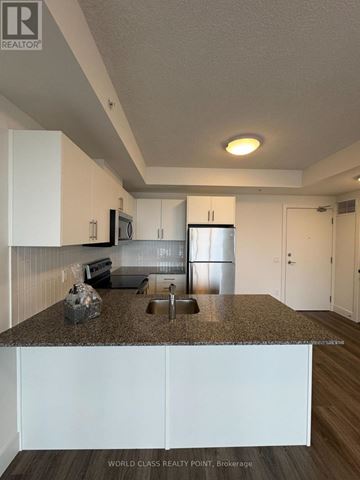 Waterloo condo for rent - A kitchen with white cabinets and a granite countertop.