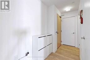 Toronto (Bay Street Corridor) condo for rent - A white hallway with a door and a fire extinguisher on the wall.