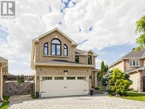 Vaughan (Maple) apartment for rent - A large house with a garage is surrounded by a fence and has a driveway.