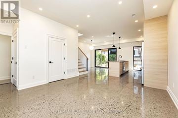 Toronto (Dovercourt-Wallace Emerson-Junction) apartment for rent - A spacious, well-lit living room with a marble floor and a staircase leading to the upper level.
