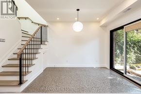 Toronto (Dovercourt-Wallace Emerson-Junction) apartment for rent - A spacious room with a staircase and a hanging light fixture.