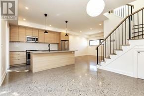 Toronto (Dovercourt-Wallace Emerson-Junction) apartment for rent - A spacious kitchen with a granite countertop and a staircase with black railings.