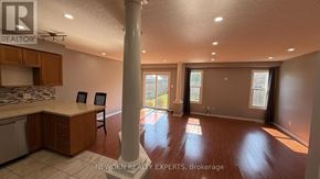 Kitchener apartment for rent - A real estate photo of a kitchen and living room with a dining table and chairs.