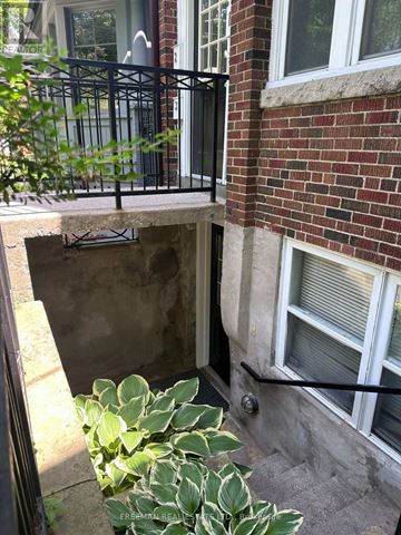 Toronto (Annex) apartment for rent - A brick building with a window and a plant in front.