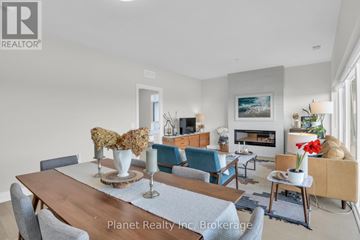 Guelph (St. Patrick's Ward) condo for rent - A modern living room with a wooden dining table and blue chairs.