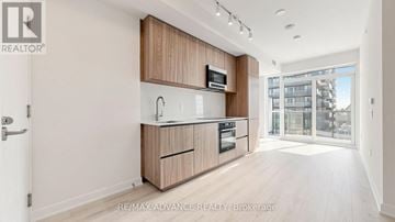 Toronto (Mount Pleasant West) condo for rent - A modern kitchen with wooden cabinets and appliances.