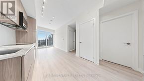 Toronto (Mount Pleasant West) condo for rent - A modern kitchen with white cabinets and a wooden floor.