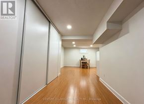 Toronto (Milliken) apartment for rent - A room with wooden floors and white walls, with a table and chairs in the middle.