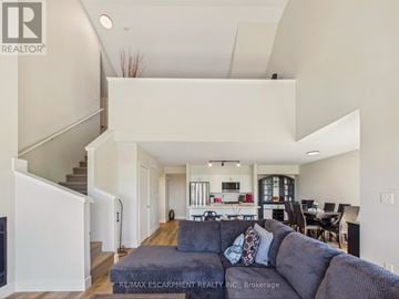 Huntsville (Chaffey) townhouse for rent - A living room with a grey couch and a staircase on the left side.