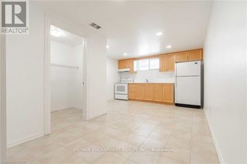 Hamilton (Gershome) apartment for rent - A kitchen with white appliances and wooden cabinets.