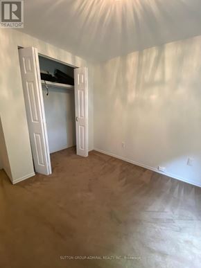 Toronto (South Riverdale) multi-family for rent - A room with a brown carpet and white walls with a doorway open.