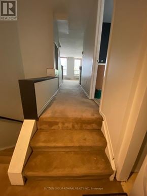 Toronto (South Riverdale) multi-family for rent - A staircase with a white railing and a brown carpet.